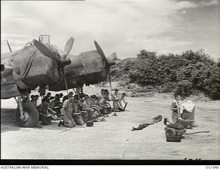 KIRIWINA, TROBRIAND ISLANDS, PAPUA. C. 1944-04. SERVICING CREWS OF NO. 30 (BEAUFIGHTER) SQUADRON RAAF KNEELING AT AN EASTER SUNDAY CHURCH SERVICE HELD IN FRONT OF A BEAUFIGHTER AIRCRAFT IN THE ..