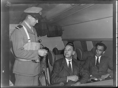 Captain demonstrating inflation of life jacket to unidentified male passengers on Tasman Empire Airways air boat RMA New Zealand ZK-AME flight to Fiji