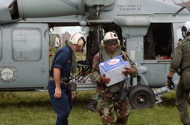 US Navy (USN) Lieutenant Commander (LCDR) Erik Threet (center), and medical professionals assigned to the Military Sealift Command (MSC) Hospital Ship USNS MERCY (T-AH 19) [not shown], unload water from the cabin of an MH-60S Seahawk helicopter, Helicopter Combat Support Squadron 5 (HC-5), Andersen Air Force Base (AFB), Guam. At the request of the government of Indonesia, MERCY and the MSC Combat Stores Ship USNS NIAGARA FALLS (T-AFS 3) [not shown] are on station off the coast of Nias, providing assistance as determined appropriate and necessary with earthquake disaster relief efforts and provide medical assistance to those in need