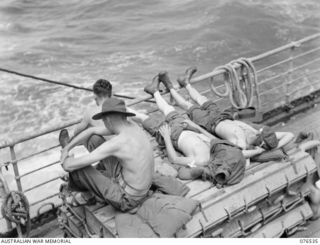 AT SEA, NEW GUINEA. 1944-10-06. TROOPS OF THE 36TH INFANTRY BATTALION RELAXING OF THE AFTERDECK OF THE DUTCH TROOPSHIP, "SWARTENHONDT", WHILE ENROUNTE TO NEW BRITAIN