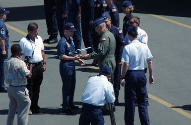 US Air Force (USAF) Major (MAJ) Jonathan Bradley of the 15th Aircraft Maintenance Squadron (AMXS) presents General (GEN) William Begert with a C-37 Tweet aircraft model before General Begert boards a C-20 Gulfstream jet (not shown) in which he will pilot his final flight at Hickam Air Force Base (AFB), Hawaii (HI)