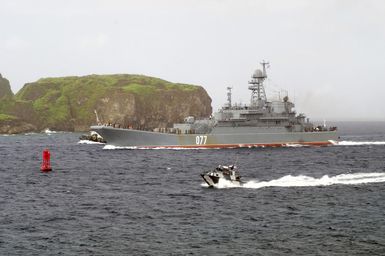 The Russian Federated Navy (RFN) Tank Landing Ship BDK 11 (RFN 077) navigates through Apra Harbor, Guam (GU), as a US Navy (USN) Harbor Patrol Boat (HPB) secures the area. The BDK 11 (RFN 077) participated in Passing Exercise (PASSEX) 2006, off the coast of Guam