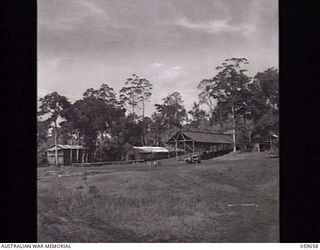SOGERI, NEW GUINEA. 1943-11-04. PARADE GROUND AND BARRACKS OF THE JUNIOR LEADERS WING AT THE NEW GUINEA FORCE TRAINING SCHOOL. BARRACKS ARE BUILT IN NEW GUINEA STYLE