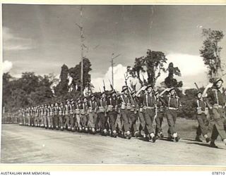 BOUGAINVILLE ISLAND. 1945-01-26. TROOPS OF "C" COMPANY, 58/59 INFANTRY BATTALION GIVE "EYES RIGHT" AS THEY MARCH PAST THE SALUTING BASE AT THE CONCLUSION OF AN INSPECTION OF THE UNIT BY THE GENERAL ..