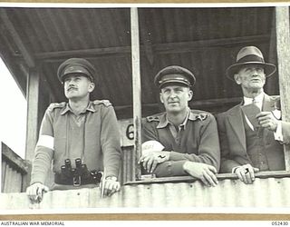 HERBERTON, QLD. 1943-06-12. THE JUDGES AND TIMEKEEPER IN THE JUDGES BOX AT THE 6TH AUSTRALIAN DIVISION RACE MEETING. LEFT TO RIGHT:- JUDGES-LIEUTENANT K. F. CURTIS, 2/2ND INFANTRY BATTALION, AND ..