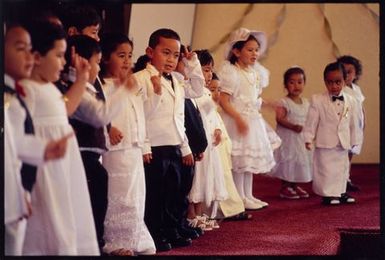 Children led by Sekone Fepuleaʻi performing for an audience on White Sunday