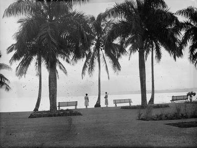 [Two women look out to sea from Pacific Island waterfront]