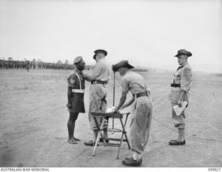 RABAUL, NEW BRITAIN, 1946-02-14. MAJOR GENERAL K.W EATHER, GENERAL OFFICER COMMANDING 11 DIVISION, PRESENTING THE MILITARY MEDAL TO SERGEANT TAPIOLI, 3 NEW GUINEA INFANTRY BATTALION, DURING A ..