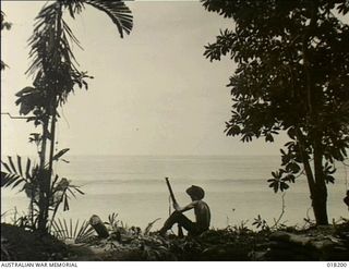Aitape, New Guinea. 2 March 1945. Private Jack Carlson of Melbourne, Vic, resting while on duty at the water's edge keeping a constant watch for signs of any enemy activity