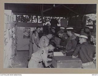 TOROKINA, BOUGAINVILLE. 1945-05-07. GENERAL VIEW OFFICERS PURCHASING GOODS AT MAIN COUNTER OF 4 SECTION OFFICERS' SHOP. IDENTIFIED PERSONNEL ARE:- CORPORAL S.G. BOWDEN (1); STAFF SERGEANT S.R. ..