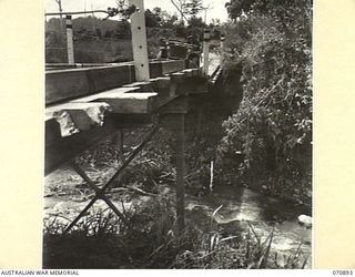 WAU - LAE ROAD, NEW GUINEA, 1944-02-26. A MONTH OLD STEEL GIRDER BRIDGE ACROSS BANDA CREEK CONSTRUCTED BY MEMBERS OF THE 1ST MECHANICAL EQUIPMENT PLATOON, 2/1ST RAILWAY CONSTRUCTION COMPANY ..