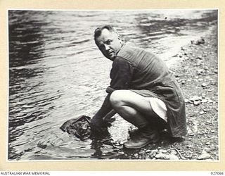PAPUA, NEW GUINEA. 1942-10. THE PADRE OF THE 2/33RD AUSTRALIAN INFANTRY BATTALION WASHES HIS SHORTS IN THE BROWN RIVER DURING THE TRACK ACROSS THE OWEN STANLEY RANGES