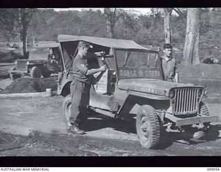 RABAUL, NEW BRITAIN, 1946-03-30. MEMBERS OF MOBILE CINEMA UNIT 137, AUSTRALIAN ARMY AMENITIES SERVICE, LOADING THEIR JEEP IN PREPARATION FOR A SHOW AT ONE OF THE UNIT SITES. SIX OF THESE UNITS ..