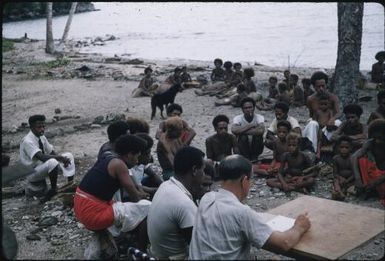Colin Fisher (Malaria Control Officer) and Kairi Fae (Malaria Control Assistant) hold prespraying meeting with villagers at Igwageta village (2) : Fergusson Island, D'Entrecasteaux Islands, Papua New Guinea, 1959 / Terence and Margaret Spencer