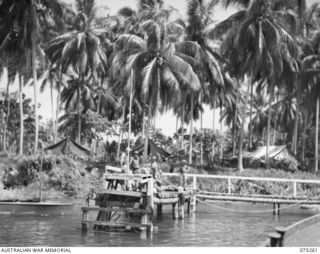 MATUPI, NEW BRITAIN. 1944-08-18. PASSENGERS AND GEAR AT THE WHARF OF THE 11TH FIELD AMBULANCE AWAITING THE ARRIVAL OF THE MEDICAL LAUNCH AM1567, OF THE NEW GUINEA SEA AMBULANCE TRANSPORT COMPANY, ..