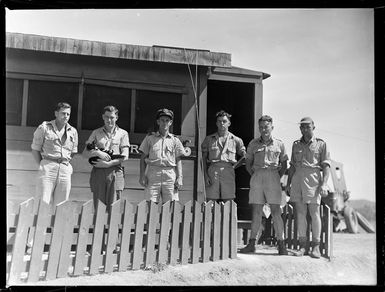 Tontouta Airfield and unidentified RNZAF personnel standing in front of a wooden building with a cat, New Caledonia