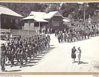 HERBERTON, QLD. 1944-04-25. PERSONNEL OF THE 6TH DIVISION MARCHING ALONG THE MAIN STREET TO THE DISPERSAL AREA AT THE CONCLUSION OF THE ANZAC DAY SERVICE AT THE WAR MEMORIAL. IDENTIFIED PERSONNEL ..