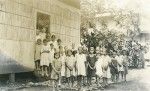 Girls going out of a bamboo hut which serves as a library or as a classroom for religion lessons, Papeete