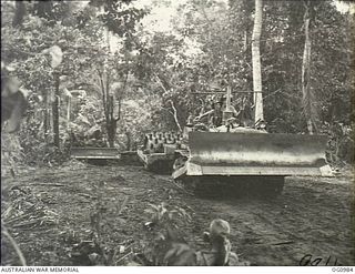 AITAPE, NORTH EAST NEW GUINEA. C. 1944-04. CRASHING THROUGH THE JUNGLE ON GRADERS AND ROLLERS, MEMBERS OF NO. 7 MOBILE WORKS SQUADRON RAAF SET ABOUT PREPARING ANOTHER AIRSTRIP FOR ALLIED AIRCRAFT