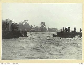 LAE, NEW GUINEA. 1944-08-09. TROOPS OF THE 20TH FIELD COMPANY, SURVEYING THE DAMAGE DONE TO THE BUTIBUM BRIDGE BY THE FLOODS WHICH WERE CAUSED BY THE VERY HEAVY RAINS IN THE CATCHMENT AREA