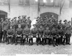 An outdoors group portrait of the Commanding Officer, Adjutant, and members of the Headquarters Details of the 2nd Australian Field Artillery Brigade.  Identified are; Interpreter Gregoire, wearing ..
