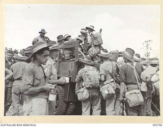 WEWAK AREA, NEW GUINEA. 1945-05-31. TROOPS OF 111 AND 119 SUPPLY DEPOT PLATOONS WAITING FOR TRANSPORT TO THEIR CAMP AT CAMP MOEM AFTER DISEMBARKING FROM THE SS SUVA, THE SECOND TROOPSHIP TO ENTER ..