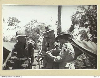 BOUGAINVILLE. 1945-03-31. LORD WAKEHURST, GOVERNOR OF NEW SOUTH WALES (2), AND LADY WAKEHURST (3), EXAMINING A CAPTURED JAPANESE SWORD DURING THEIR VISIT TO THE NORTH BOUGAINVILLE AREA. ALONGSIDE ..