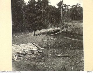 WAMPIT, NEW GUINEA, 1944-03-2. TWO BRIDGES CROSSING THE GARAGOS RIVER 71 MILES FROM WAU ON THE WAU - LAE ROAD SECTION. THE ROAD, WHICH IS IN THE JURISDICTION OF HEADQUARTERS, COMMANDER ROYAL ..