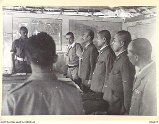 CAPE WOM, NEW GUINEA, 1945-09-13. JAPANESE STAFF OFFICERS BEING INTRODUCED THROUGH INTERPRETERS TO OFFICERS OF 6 DIVISION, AT A CONFERENCE BETWEEN AUSTRALIAN STAFF OFFICERS, HEADED BY ..
