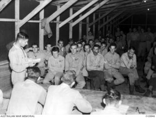 KIRIWINA, TROBIAND ISLANDS, PAPUA. C. 1944-03. IN THE AIRMEN'S MESS OF NO. 30 (BEAUFIGHTER) SQUADRON RAAF: OFFICERS VERSUS AIRMEN IN A DEBATE ON THE TOPIC OF MERCY KILLING