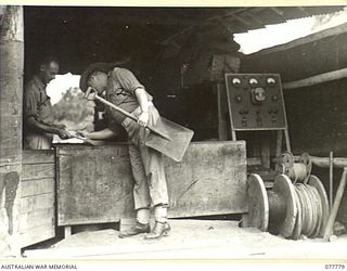 LAE BASE AREA, NEW GUINEA. 1944-12-29. NX131661 WARRANT OFFICER II, G.R. STUART, QUARTERMASTER (1) ISSUING NX167608 SERGEANT B.F. COLLINS, COMPANY SERGEANT MAJOR (2) WITH WORKING EQUIPMENT FROM THE ..