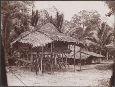 Two men standing in front of a house at Regi, Ysabel, Solomon Islands, 1906 / J.W. Beattie