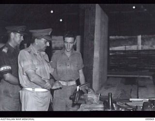 RABAUL, NEW BRITAIN, 1946-04-05. MAJOR-GENERAL B.M. MORRIS, GENERAL OFFICER COMMANDING 8 MILITARY DISTRICT, TALKING TO CORPORAL H. MATHEWA IN THE CARPENTRY SECTION OF THE NEW AUSTRALIAN ARMY ..