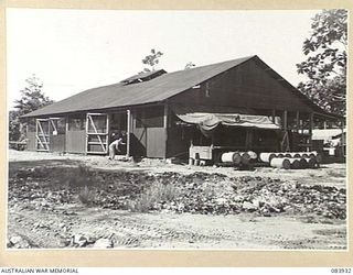 LAE, NEW GUINEA. 1944-12-12. THE ARMY CANTEENS SERVICE SOFT DRINK FACTORY, LAE BASE SUB-AREA, SHOWING THE 25 KVA ELECTRICITY GENERATING PLANT WHICH SUPPLIES POWER FOR THE MACHINERY. THE POWER OF ..