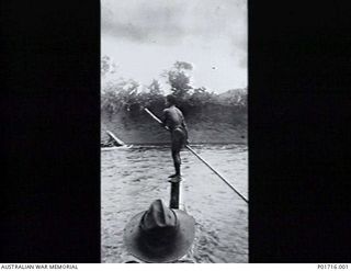 TOMA, NEW GUINEA. MEMBERS OF NO. 1 AIR SEA RESCUE SQUADRON, RAAF, ARE TRANSPORTED ACROSS A RIVER BY A POLE OARSMAN. THEY HAD LANDED A TIGER MOTH AIRCRAFT ON A STRIP 150 YARDS L0NG ON ONE SIDE OF ..
