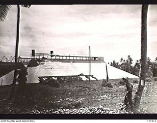 NAURU ISLAND. 1945-09-16. A MEMBER OF THE 31/51ST INFANTRY BATTALION INSPECTING THE WRECKED PHOSPHATE CRUSHING FACTORY SOON AFTER THE UNIT HAD TAKEN OVER THE ISLAND FROM THE JAPANESE