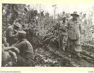 1943-01-14. ROAD BUILDERS FOLLOWING UP THE ADVANCING ALLIED TROOPS. TANKS SLITHERED ALONG THIS PATH IN THE FIGHT AGAINST THE JAPS AND INFANTRY, CARRYING HEAVY EQUIPMENT, OFTEN SANK TO THEIR KNEES ..