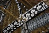 Fiji, decorated roof supports inside home in Yasawa Islands