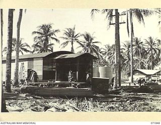 LAE, NEW GUINEA. 1944-03-29. THE 5,000 CUBIC FEET FREEZER AT THE 39TH SUPPLY DEPOT COMPANY, WITH A FIELD BAKERY IN THE BACKGROUND. CONSTRUCTION WORK PROCEEDS ON A NEW 20,000 CUBIC FEET FREEZER ..