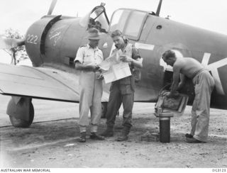 TOROKINA, BOUGAINVILLE ISLAND, SOLOMON ISLANDS. 1945-07-23. FLIGHT LIEUTENANT HARRY GRIFFITHS, MOSMAN, NSW (LEFT), CHECKING MAP DETAILS WITH FLYING OFFICER KEVIN DAWES, TOORAK GARDENS, SA, WHO HAS ..