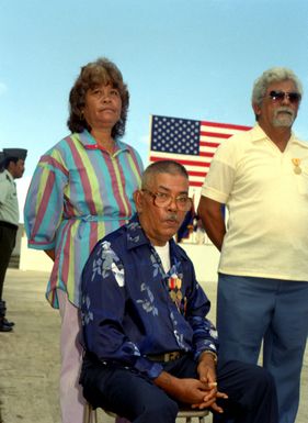 Mrs. Borja stands behind her husband, Vincente Borja, a disabled World War II veteran, after he was presented the Asiatic-Pacific Campaign Medal and the World War II Victory Medal. Borja received the medals during a Veterans Day memorial service at Skinner Plaza