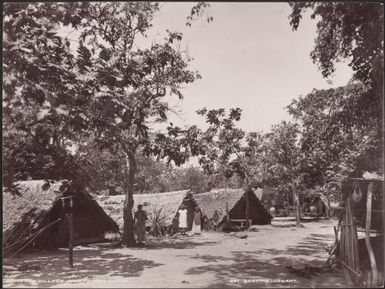 Villagers standing amongst houses in Ara, Banks Islands, 1906 / J.W. Beattie