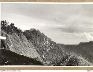 SHAGGY RIDGE, NEW GUINEA. 1943-12-27. UNITED STATES FIGHTER AIRCRAFT STRAFING JAPANESE POSITIONS ON THE "PIMPLE" DURING THE ASSAULT ON THE RIDGE BY TROOPS OF THE 2/16TH AUSTRALIAN INFANTRY ..