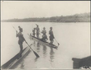 People standing and paddling two canoes, Ramu River, New Guinea, 1935 / Sarah Chinnery