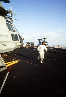 Members of the 22nd Marine Expeditionary Unit run on the flight deck of the amphibious assault ship USS GUAM (LPH-9) during morning physical training (PT)