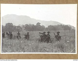 RAMU VALLEY, NEW GUINEA, 1943-10-01. MEN OF THE 2/27TH AUSTRALIAN INFANTRY BATTALION CROSSING THE VALLEY FLOOR IN THE LATE AFTERNOON