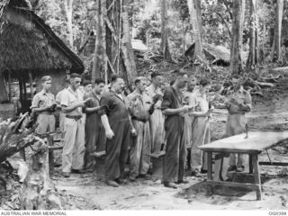 KIRIWINA, TROBRIAND ISLANDS, PAPUA. C. 1943-12. THE REVEREND ROGER S. CORRELL OF ADELAIDE, SA, CHAPLAIN, CONDUCTING AN OUTDOOR SERVICE AT NO. 14 WIRELESS TELEGRAPHY STATION RAAF