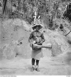 BASAMA, NEW GUINEA. 1944-07-13. KING BUMBU, HEREDITARY CHIEF OF THE HUON GULF NATIVES POSES FOR HIS PHOTOGRAPH IN CEREMONIAL DRESS