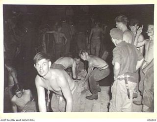 MALAGUNA MISSION, RABAUL, NEW BRITAIN, 1945-09-10. TROOPS OF 29/46 INFANTRY BATTALION, WORKED THROUGH THE NIGHT UNLOADING STORES AND EQUIPMENT TRANSPORTED TO THE BEACH-HEAD BY BARGES OPERATING TO ..