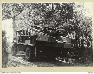 BOUGAINVILLE. 1945-04-18. A 15 FIELD COMPANY ROYAL AUSTRALIAN ENGINEERS 3-TON TRUCK CARRYING HORN BEAMS AND DECKING FOR CONSTRUCTION OF A BOX GIRDER BRIDGE OVER DAWE CREEK. TRUCK IS BACKING DOWN TO ..